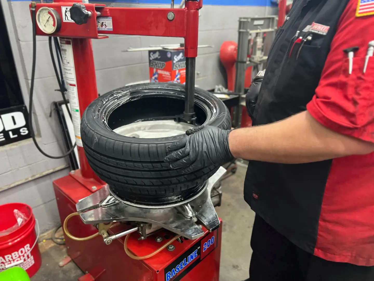 A person holding a tire on top of a machine.